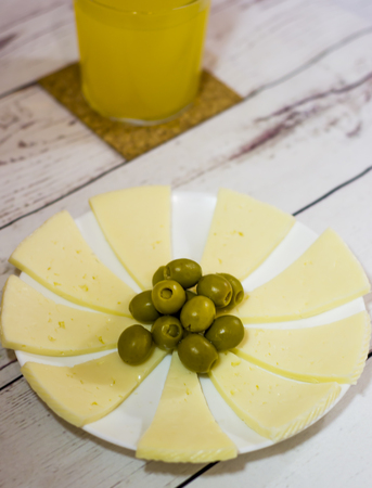 Cheese with Olives and Orange Juice. Healthy food on a white wooden tableの写真素材