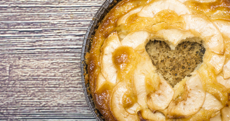 Apple pie with a hollow heart-shaped  on a wooden tableの写真素材