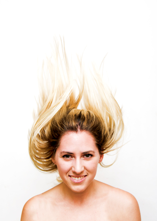 Portrait of Beautiful Blond Woman Shaking Her Hair Over White Backgroundの写真素材
