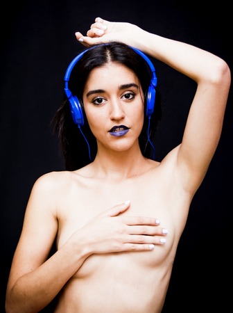 Beautiful woman with headphones on black backgroundの写真素材