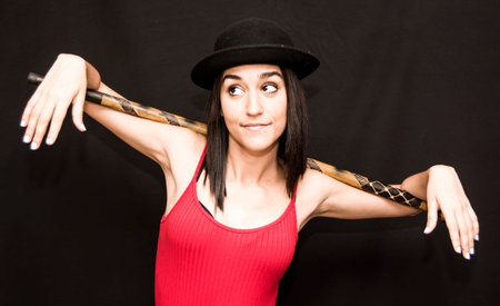 Portrait of a beautiful woman  with hat and cane on black background