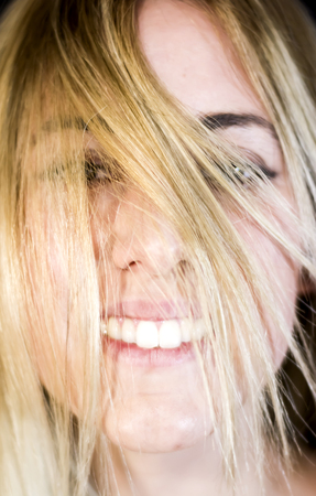 Portrait of a beautiful woman shaking her hair on black backgroundの写真素材