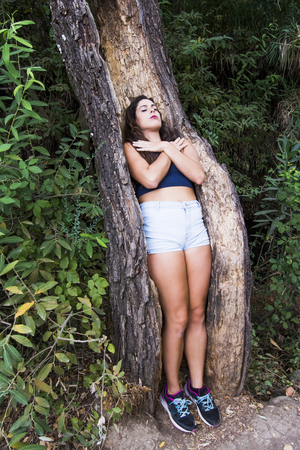 Beautiful woman sleeping in the hollow of a tree trunkの写真素材