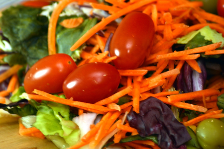 Fresh salad on a wooden plateの写真素材