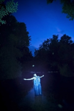 Beautiful woman on the bank of a mountain river with an evening dressの写真素材