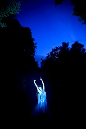 Beautiful woman on the bank of a mountain river with an evening dressの写真素材