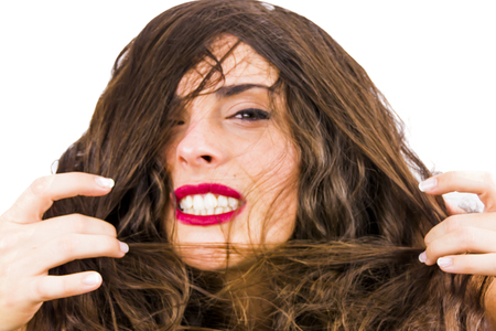 Beautiful woman removing her hair from her face on white backgroundの写真素材