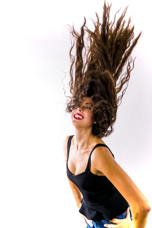Beautiful woman shaking her hair on white backgroundの写真素材
