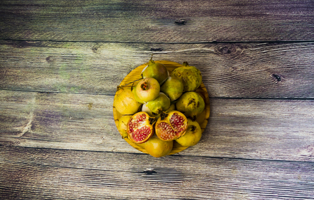 Pomegranate fruit on a wooden plateの写真素材