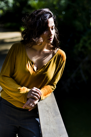 Beautiful woman on a wooden bridge in a parkの写真素材