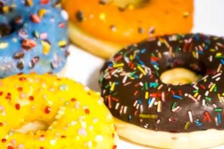 Sweet tasty donuts with colorful sprinkles isolated on white backgroundの写真素材