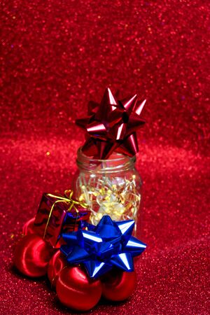 Christmas ornaments on red background with lights like starsの写真素材