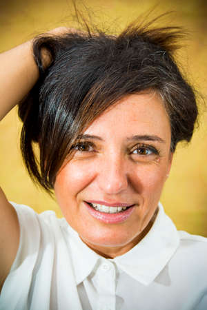 Beautiful woman with brunette hair in the park and white shirtの写真素材