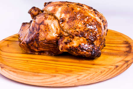 Roast chicken on a wooden tray on white backgroundの写真素材