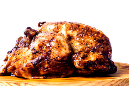 Roast chicken on a wooden tray on white background