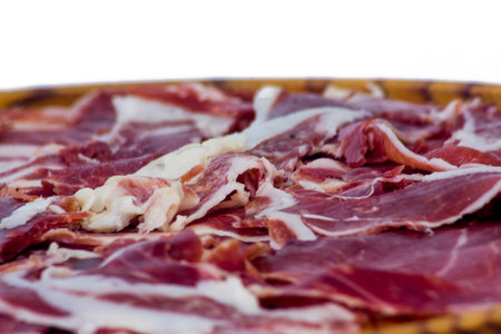 Portions of ham on wooden tray on white background