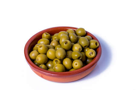 Lot of olives stuffed with anchovies in a ceramic bowl and white backgroundの写真素材