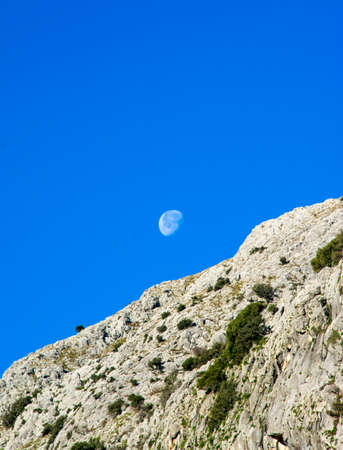 Montain landscape with the moon and blue skyの写真素材