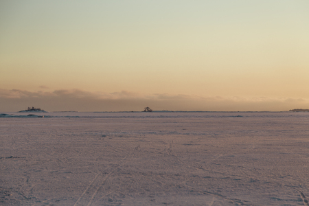 Walking on the frozen sea and looking at a sunsetの写真素材
