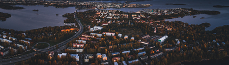 Aerial view of Lauttasaari part of Helsinki Finland with darkness falling over the island and lots of traffic on the highwayの写真素材