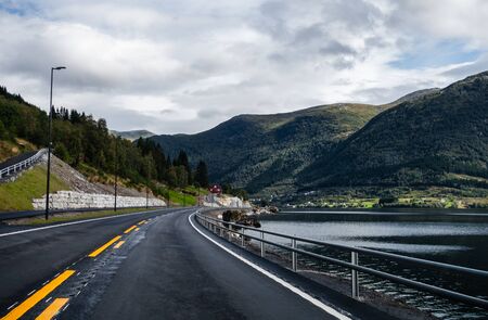 Driving on the Norwegian countryside on the side of a fjord on a bright late summer dayの写真素材