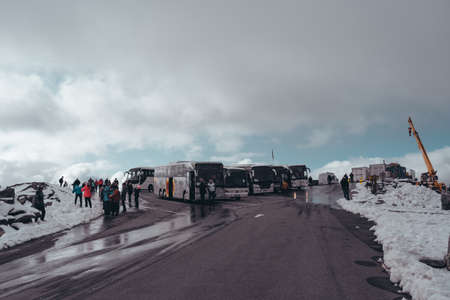 Editorial 09.07.2019 Dalsnibba Norway, buses and tourists at the parking lot on the top of Dalsnibba with snow on a bright dayのeditorial素材