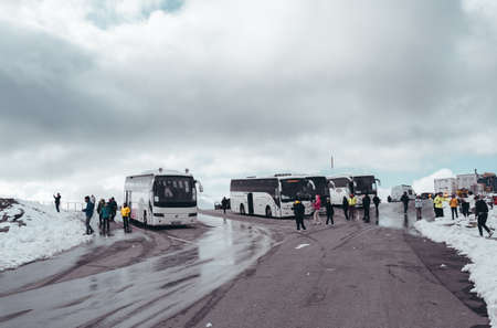 Editorial 09.07.2019 Dalsnibba Norway, buses and tourists at the parking lot on the top of Dalsnibba with snow on a bright dayのeditorial素材