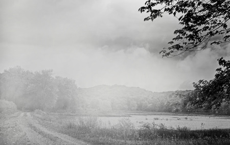 Black and white country lane by lakeの写真素材