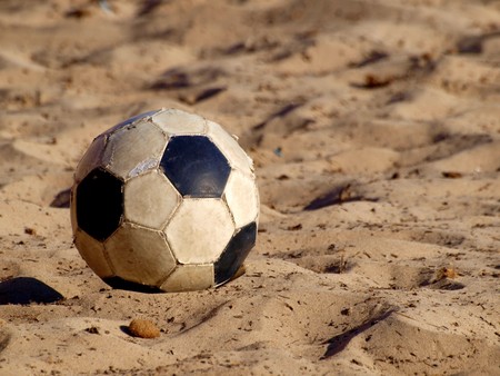 soccer ball on a beach in white and black leatherの写真素材