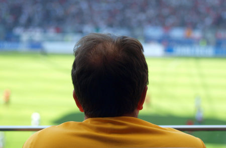 fan watches soccer game in stadium, backgound soccer fieldの写真素材