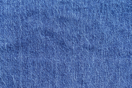 Texture of laundered light shade blue jean fabric background