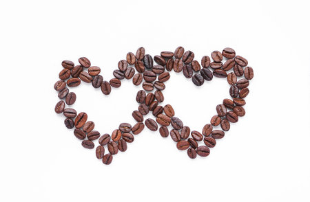 Texture of two heart shape coffee seed on white backgroundの写真素材