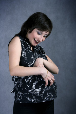 Funny pregnant with a haircut scratching her tummy