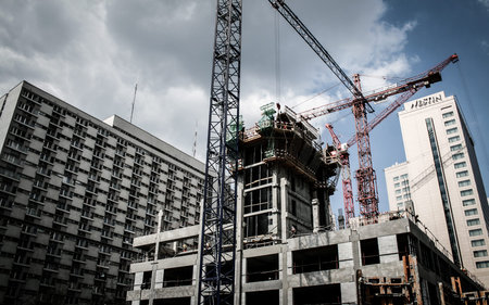 Construction site in big city with cranes and other buildings in background, Warsaw, Polandのeditorial素材