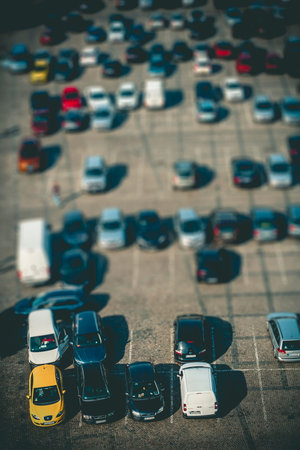 Big parking with lot of different cars seen from above with tilt shift effect