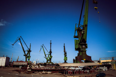 Large green single boom shipyard cranes in Gdansk shipyard, where Solidarity movement was founded in...