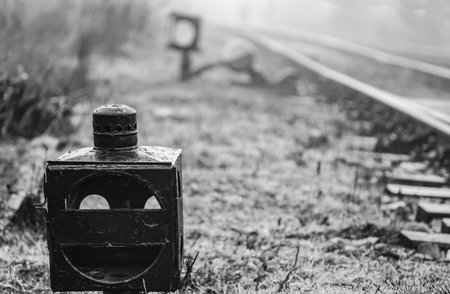 Old railroad derailer lantern at railway junction - monochrome image