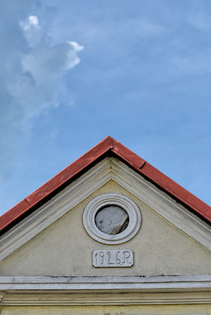 Gable wall with small round window against blue sky with copy spaceの写真素材