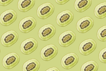 Pattern made of backlit kiwi fruit slices on green background
