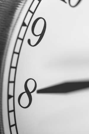 Clock hand pointing eight o'clock on white clock face of Twin bell classic alarm clockの写真素材