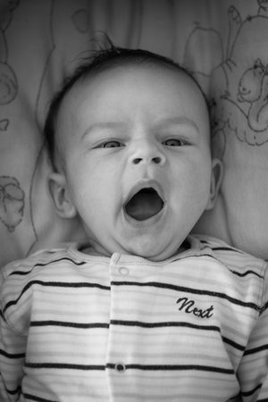 Two months old infant boy yawns, black and wahite image