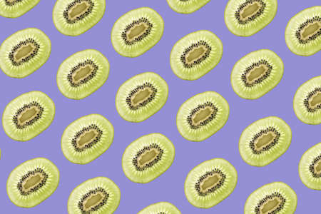 Pattern made of backlit kiwi fruit slices on blue backgroundの写真素材