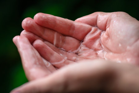 hand of thirteen years old boy catching raindrops during rain