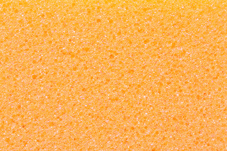 Close up on orange kitchen sponge textured backgroundの写真素材