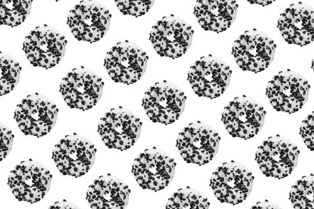 Pattern made with black and white cookie donut on white background