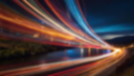 Long exposure light trails over a bridge in a city at night, capturing the vibrant movement of lights and the serene backdrop of the surrounding landscape.の写真素材