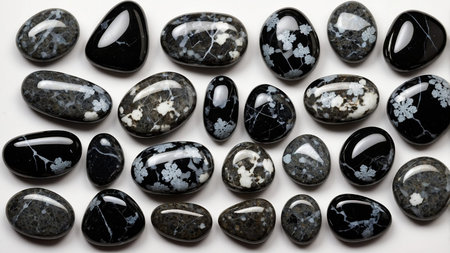 This image shows an assortment of polished stones in black, white, and gray colors, arranged neatly. The stones vary in shape and size, presenting an aesthetically pleasing array against a white backdrop. AI generated imageの写真素材