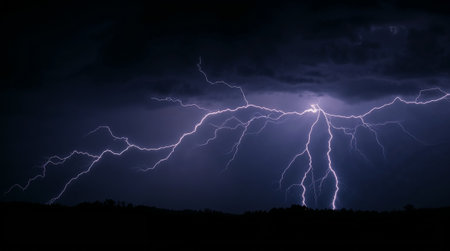 Bright lightning bolts striking from dark storm clouds over a shadowy landscape at night. Ai generated imageの素材