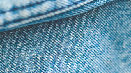 Folded denim jeans fabric texture background showing the weaving and fibers of the textileの写真素材