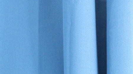 Soft blue fabric folds creating abstract shapes and shadows with a minimalist aestheticの写真素材